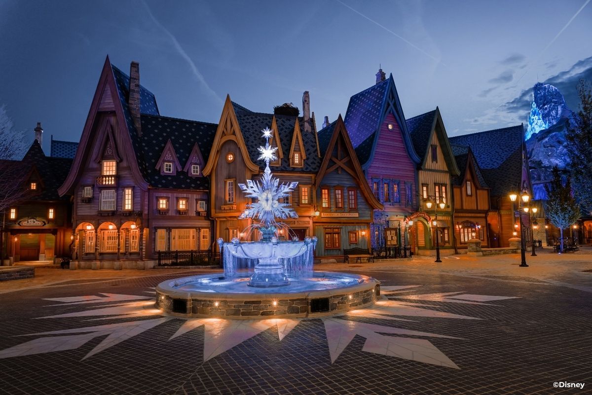 Reino de Arendelle de Frozen na Disneyland Paris com fonte no centro e casas atrás