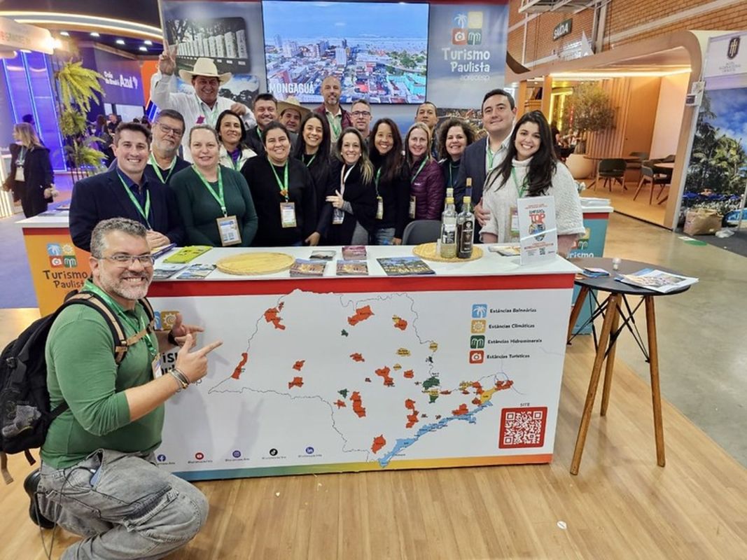 Equipe da Aprecesp em torno de um balcão com o mapa de SP