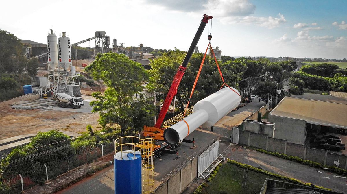 Reservatório de água Fortmetal sendo içado por guindaste para instalação em planta industrial.